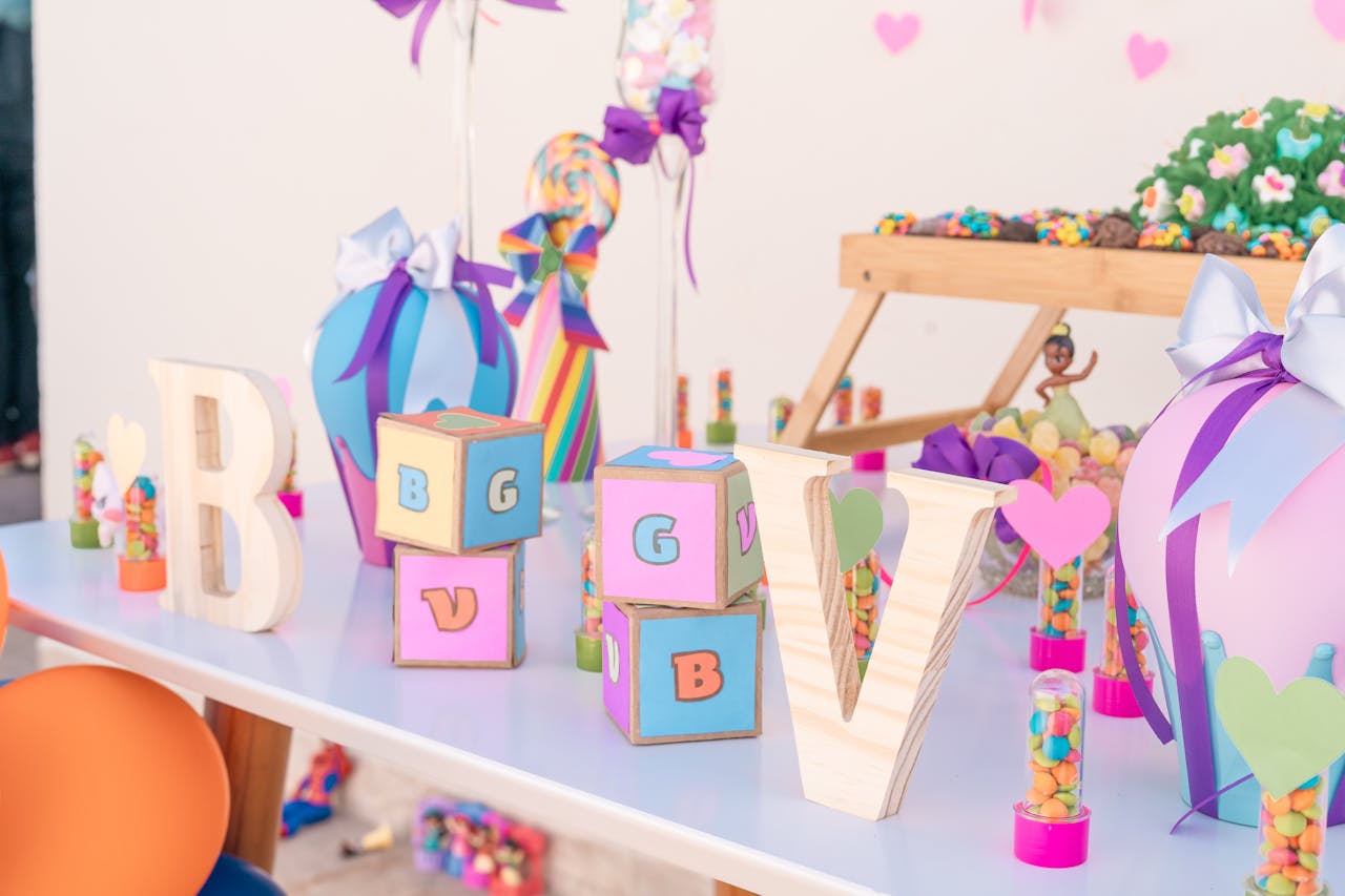about-us-01 Vibrant party setup featuring letter blocks and colorful decorations on a table.