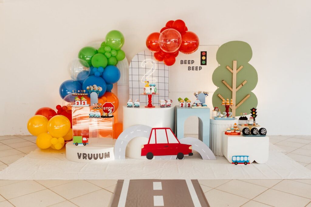 Vibrant transportation-themed children's party setup with balloons and road decorations.