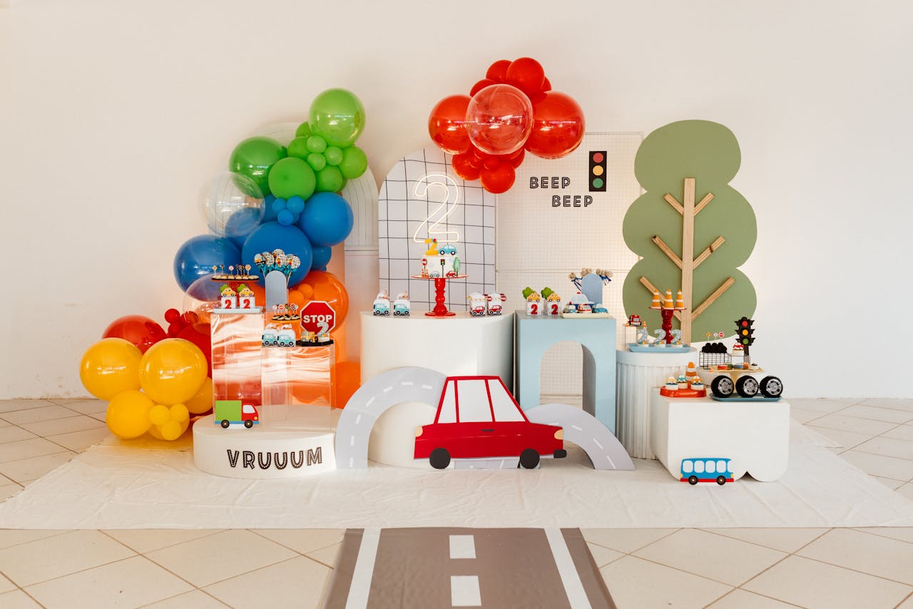 about-us-02 Vibrant transportation-themed children's party setup with balloons and road decorations.